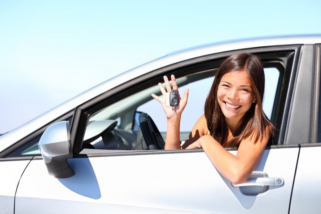 woman smiling inside her rented car