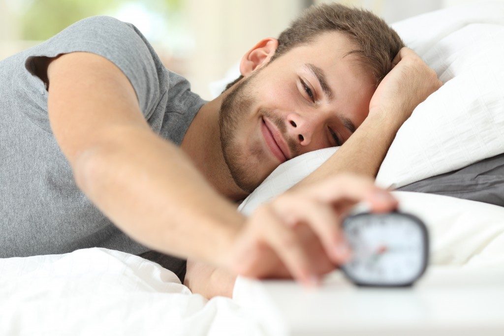Man stopping the alarm clock