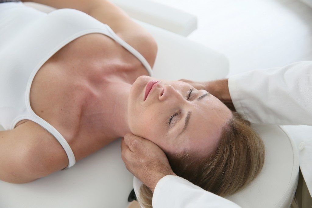 Woman having chiropractic neck adjustment