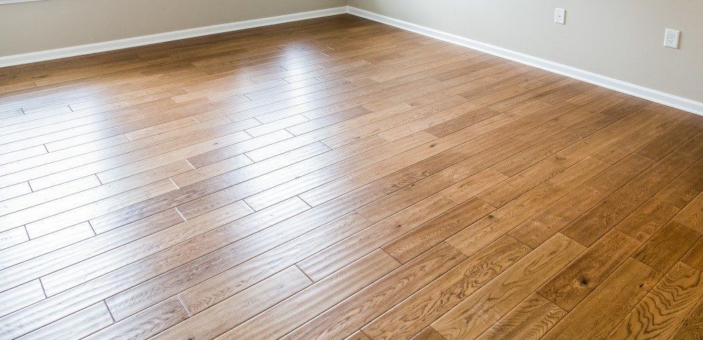 A shiny, polished hardwood floor in a new home