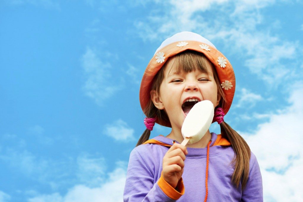 kid happily eating icecream outdoors
