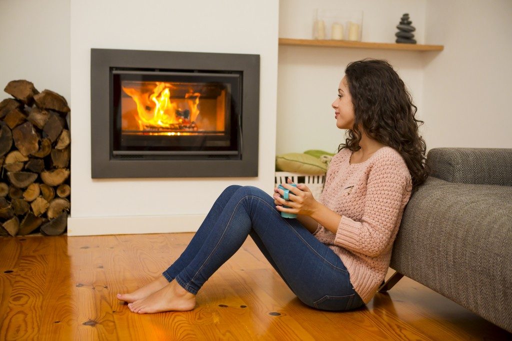 Woman next to a fireplace