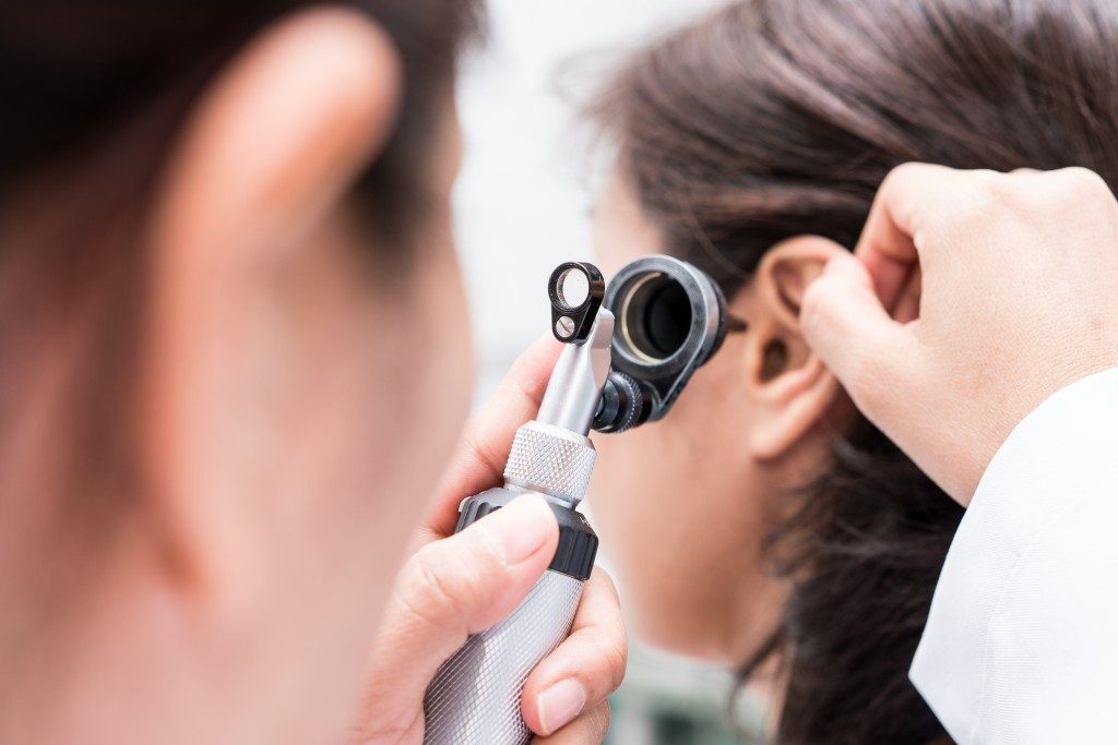doctor checking woman's ear