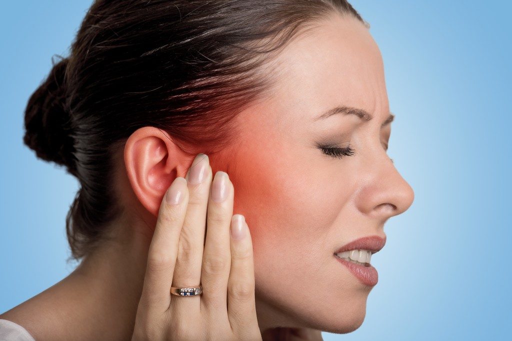 woman suffering from ear pain
