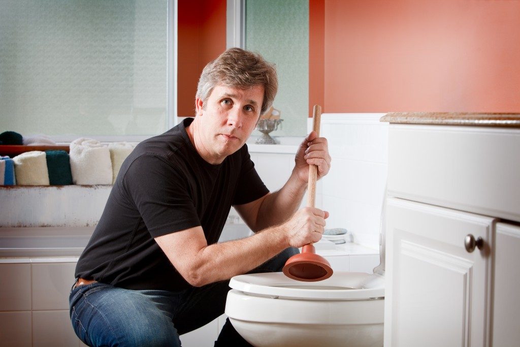 using a plunger to clear a clogged toilet