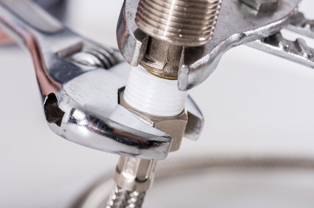 Plumber screwing plumbing fittings, closeup