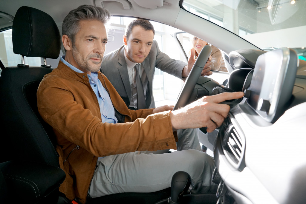 men looking at a car dashboard