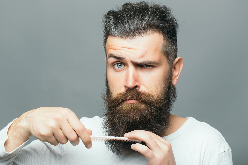man combing through his beard