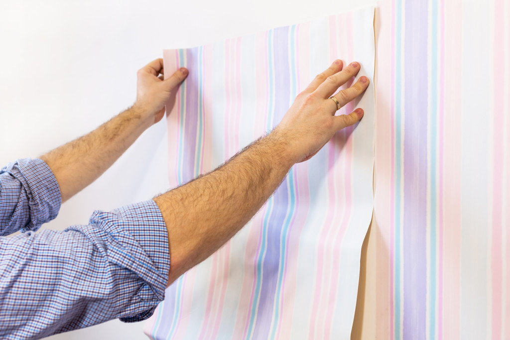 man installing wallpaper