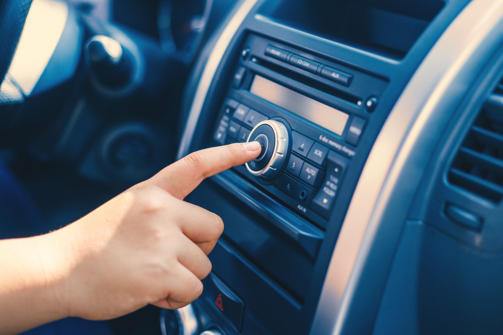 Close up portrait of a hand turning on new radio in car