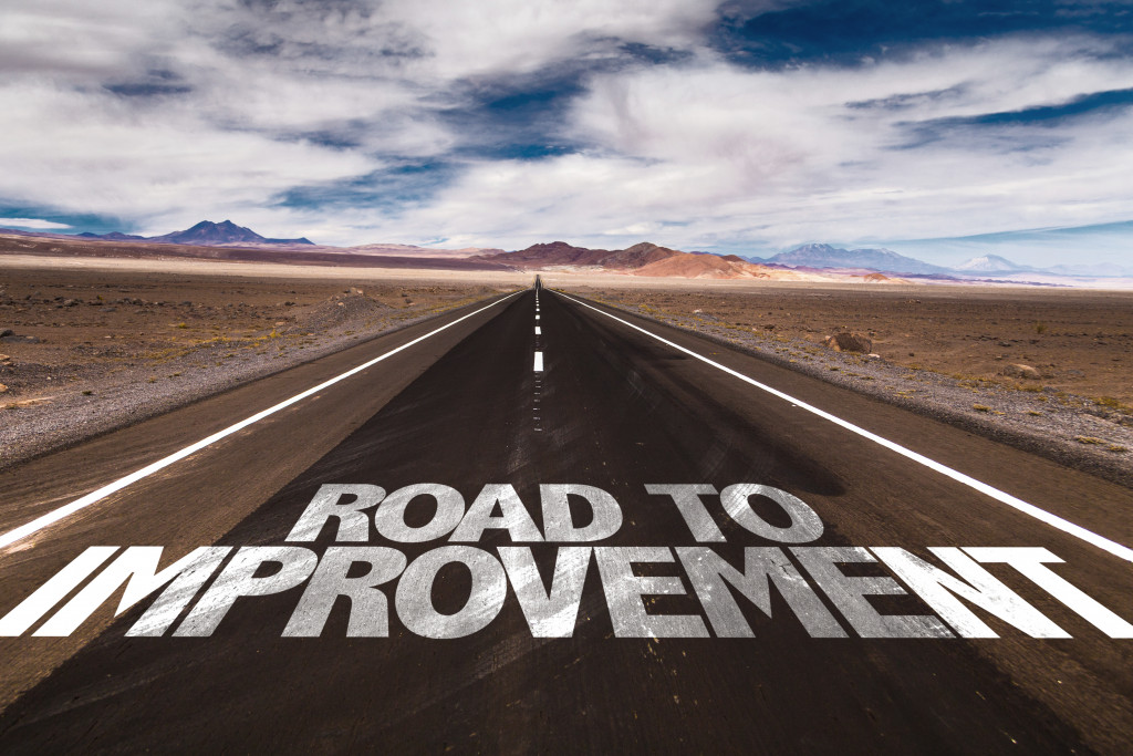 road to improvement printed on a highway