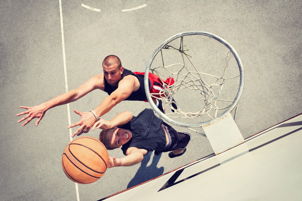 Two men playing basketball on a court.