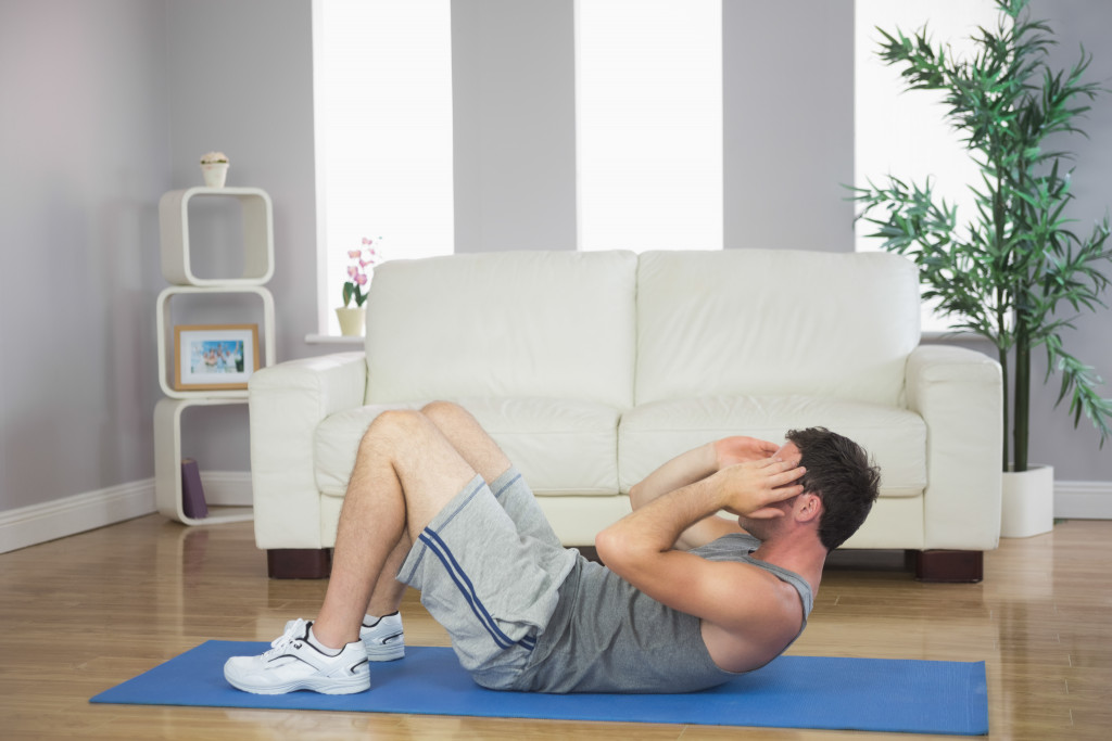 man doing sit ups in bright living room