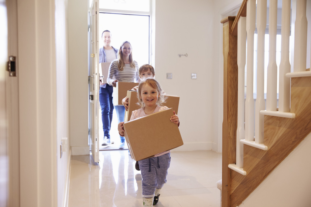 Portrait of a family carrying cartoon to shift into new home