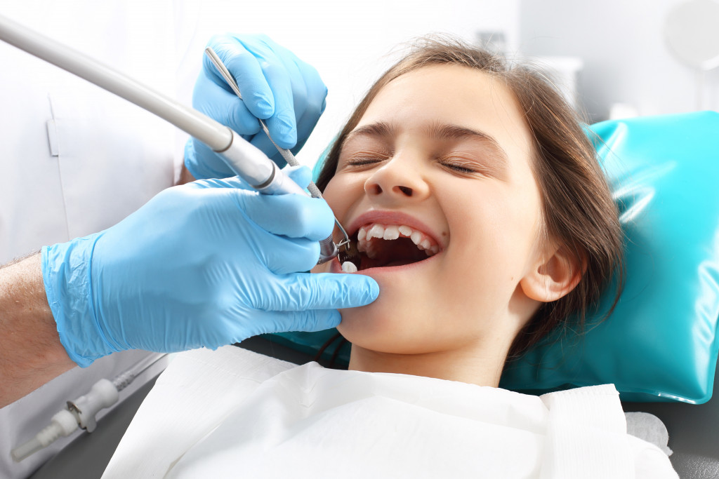 Small girl having her root canal treatment in dentist clinic 