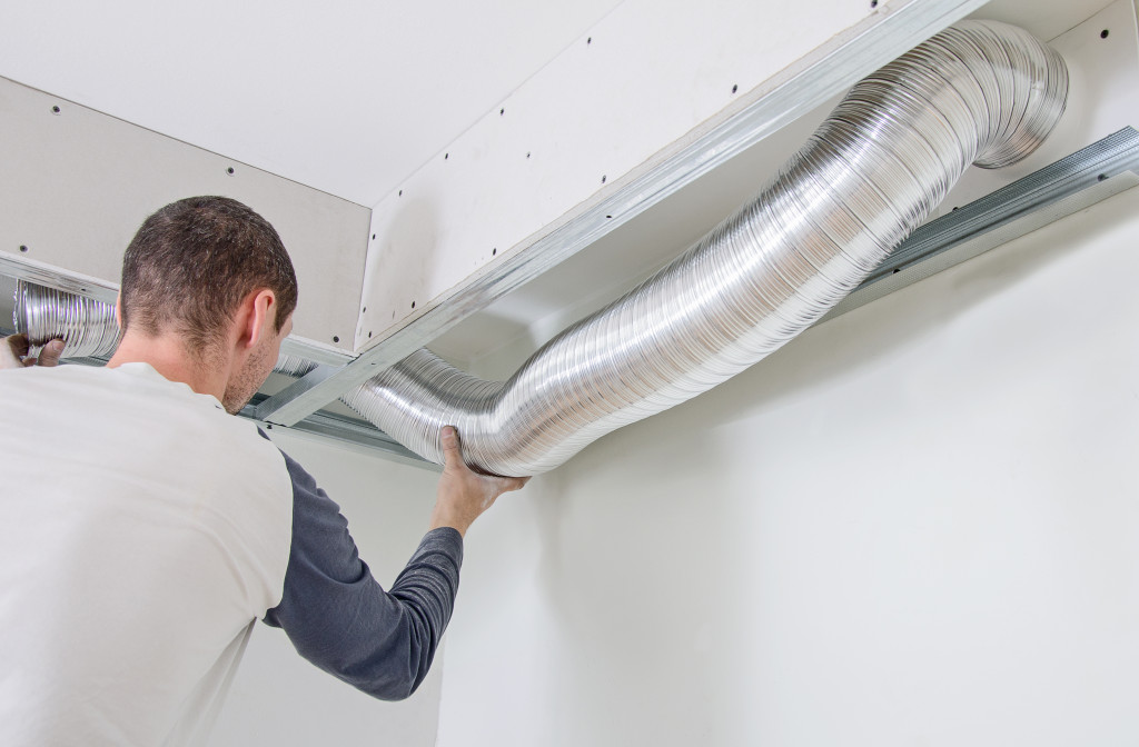 A man repairing a vent