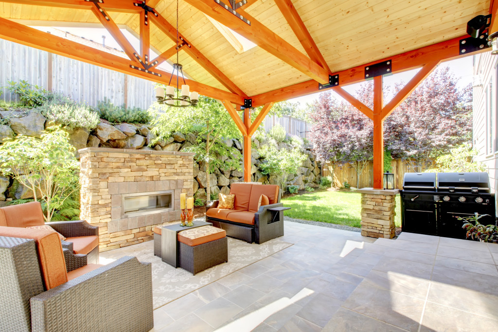 Covered patio with furniture and a fireplace.