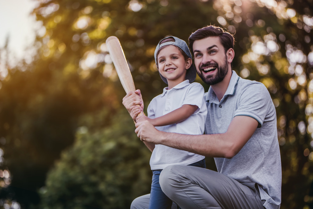 man playing baseball with a child
