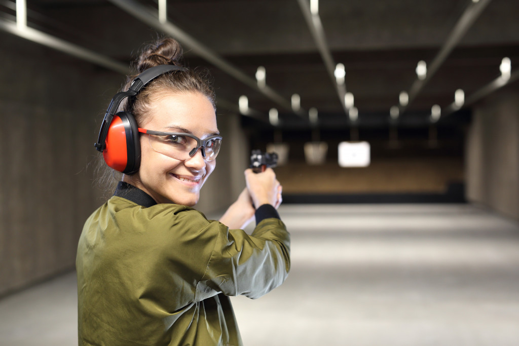 woman smiling while shooting at a shooting range