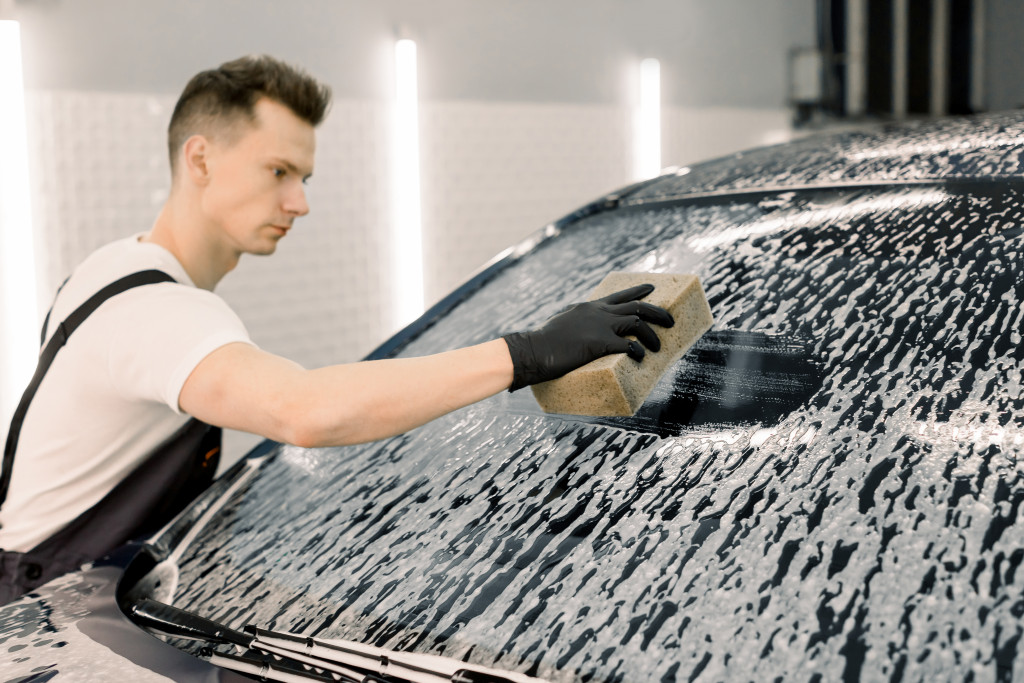 A man cleaning a car with a sponge