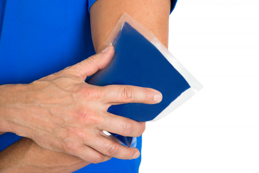 Man treating elbow sprain with ice pack